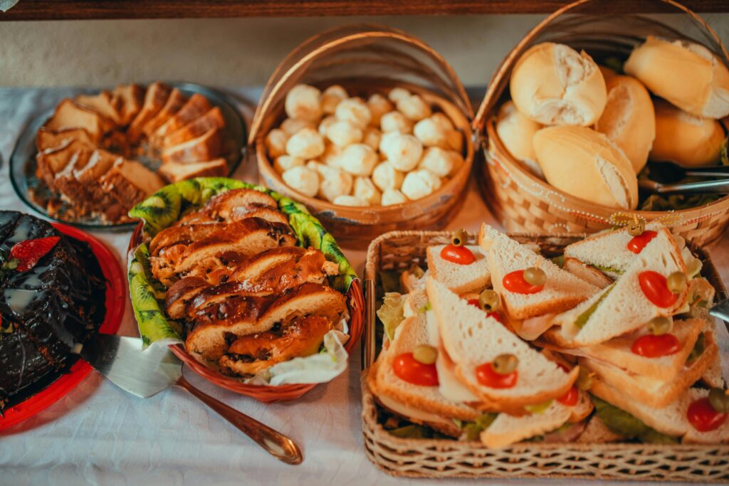 An inviting breakfast spread featuring various breads, cakes, and sandwiches on a decorative table setting.